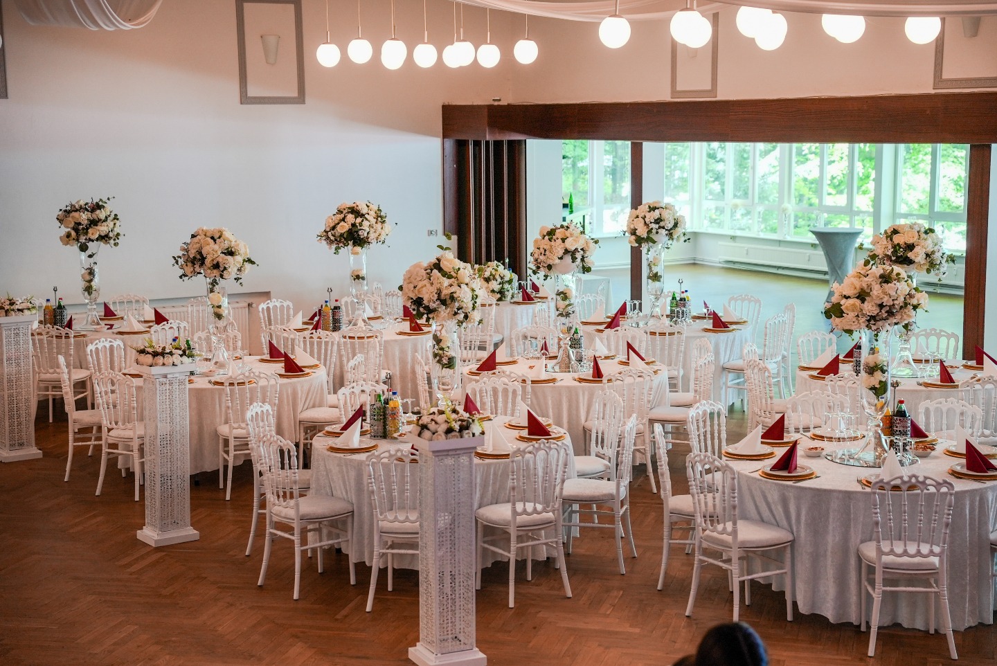 Festlich dekorierter Saal der Waldhalle Büchen mit weißen Tischdecken, Blumenarrangements und Kronleuchter